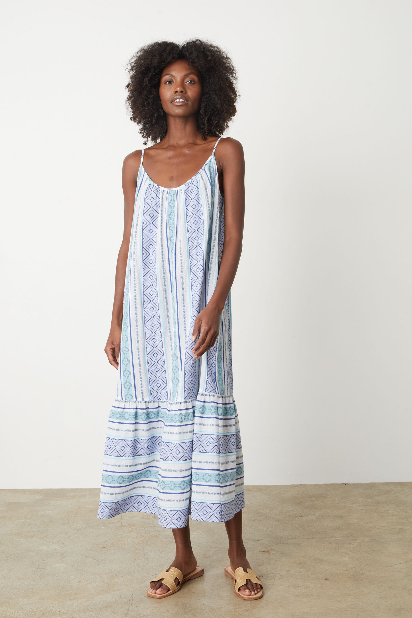 A woman wearing a Velvet by Graham & Spencer LEXY JACQUARD DRESS in blue and white stripe jacquard print full length with sandals.-26577343545537
