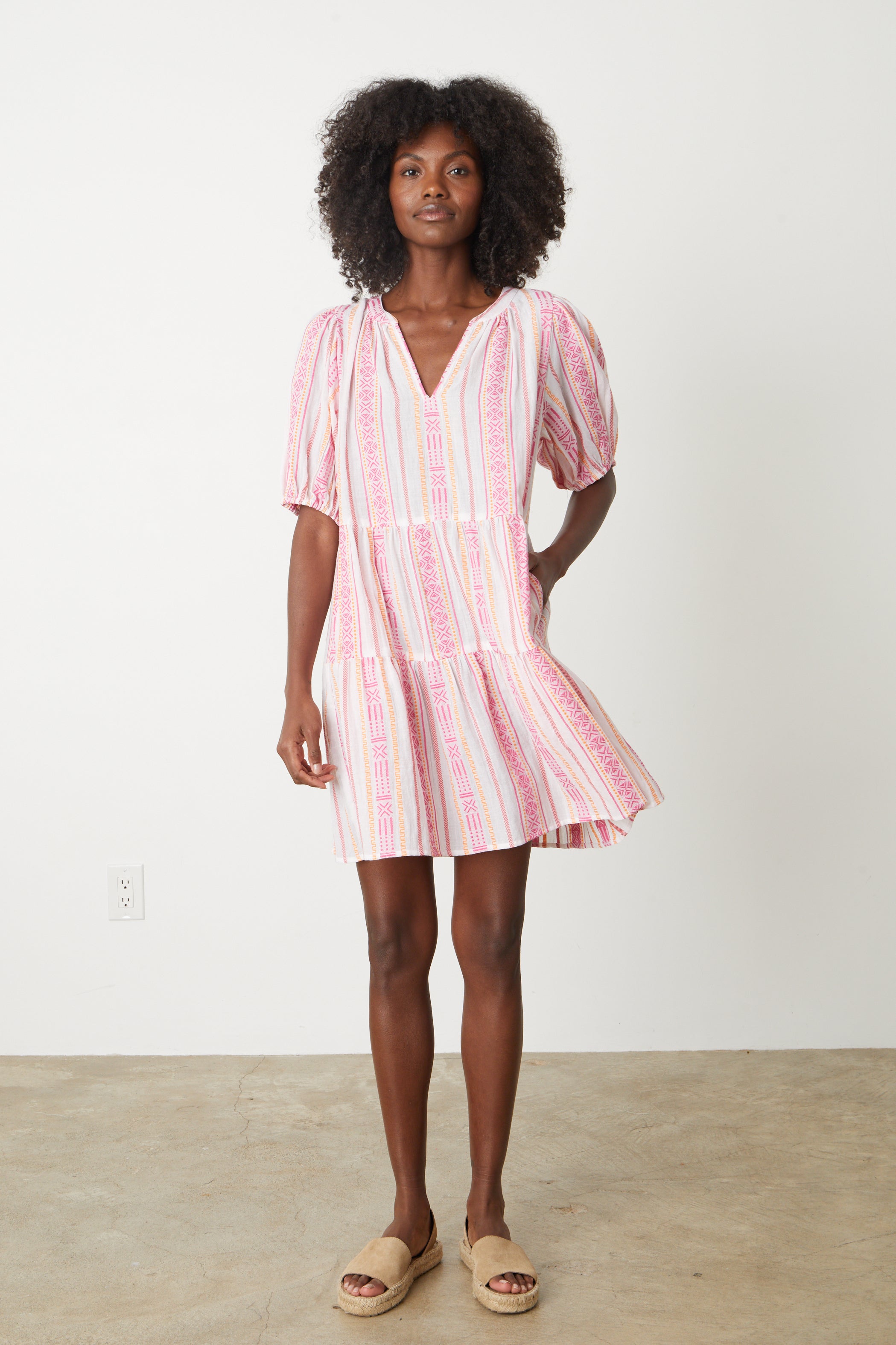   A woman wearing the MONIQUE JACQUARD BOHO DRESS by Velvet by Graham & Spencer, a pink and white striped jacquard print dress. 