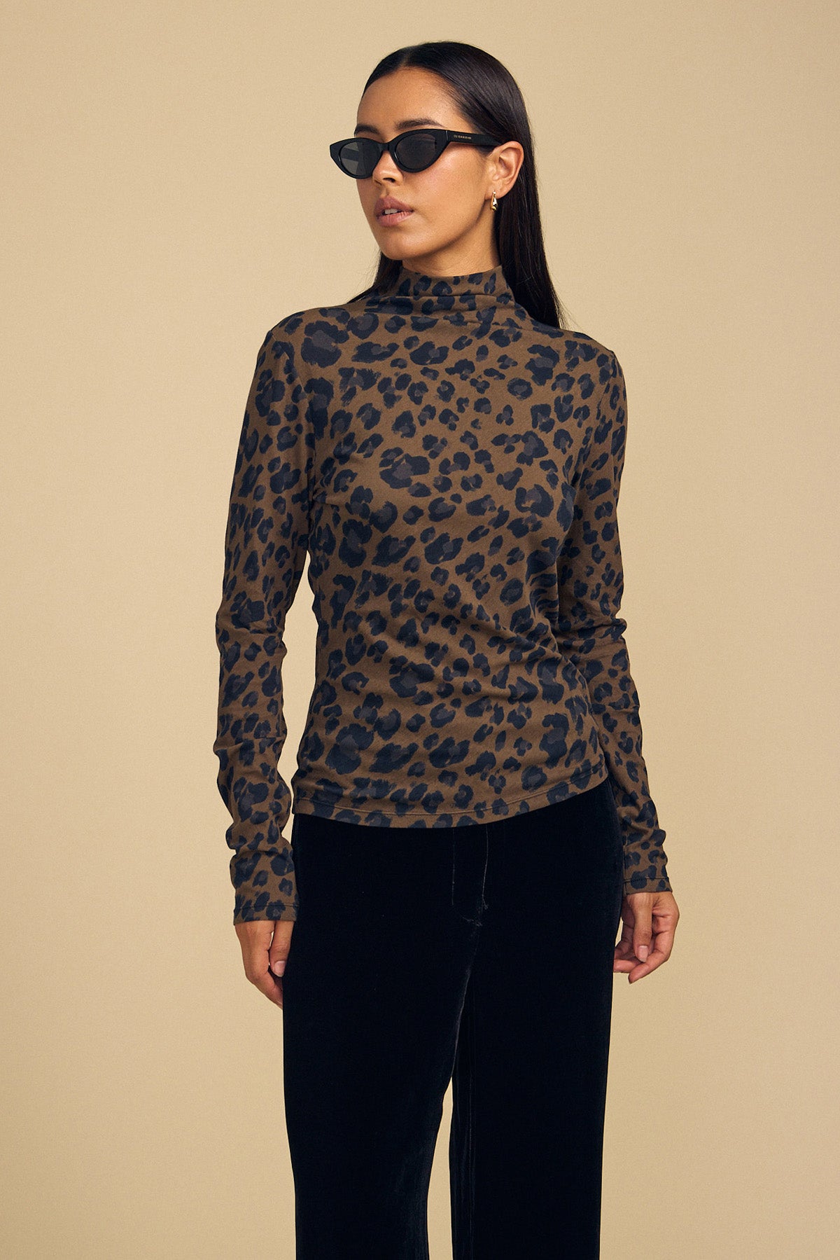 A person wearing a brown and black leopard print Velvet by Graham & Spencer ETTA TEE and black trousers.-46288349102273