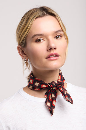 A person with light hair, wearing a white shirt and the JEWEL SCARF by Velvet by Graham & Spencer around their neck, looks directly at the camera against a plain background.