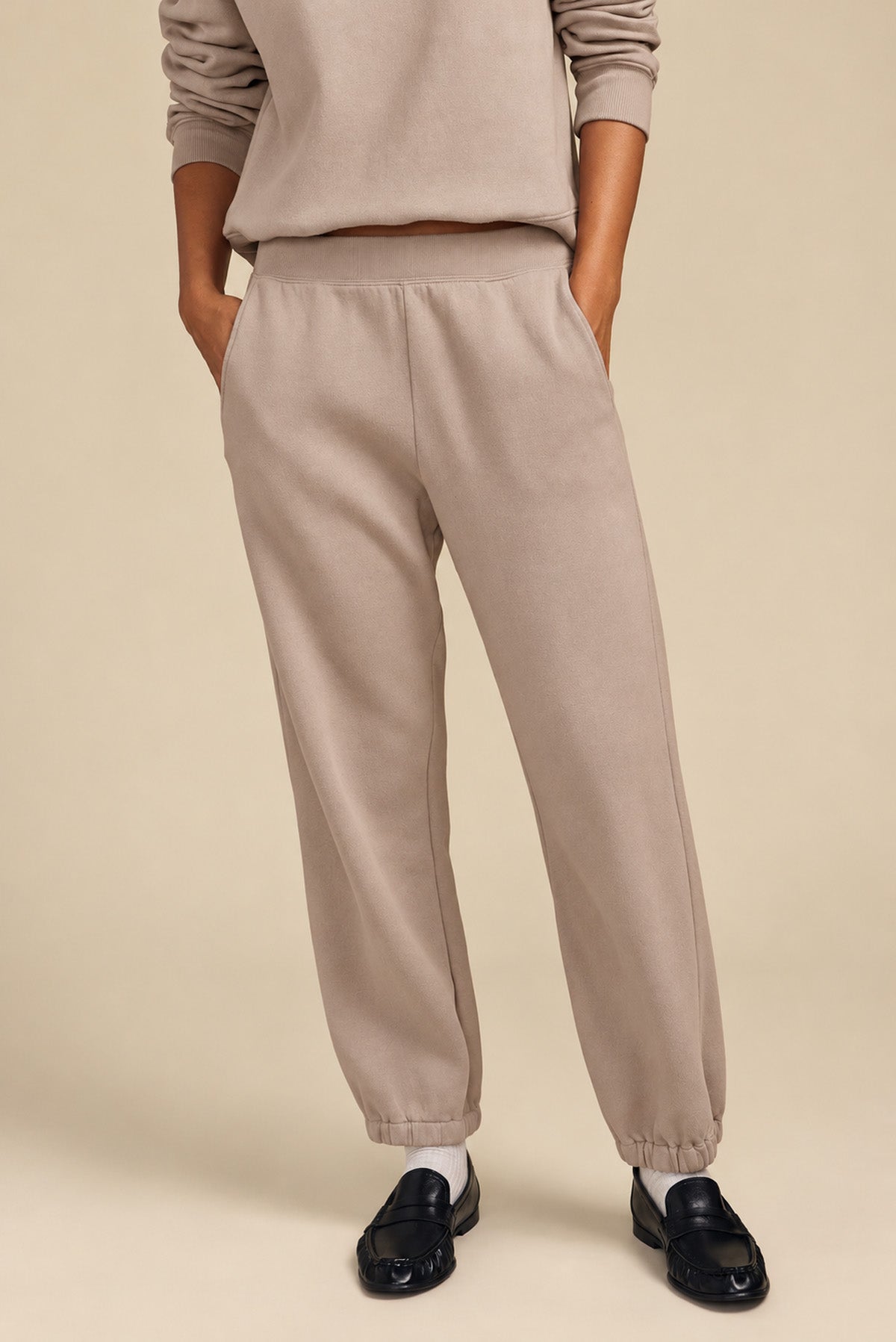 Person wearing a relaxed YOKO SWEATSHIRT and matching elastic-cuff sweatpants, styled with black loafers.