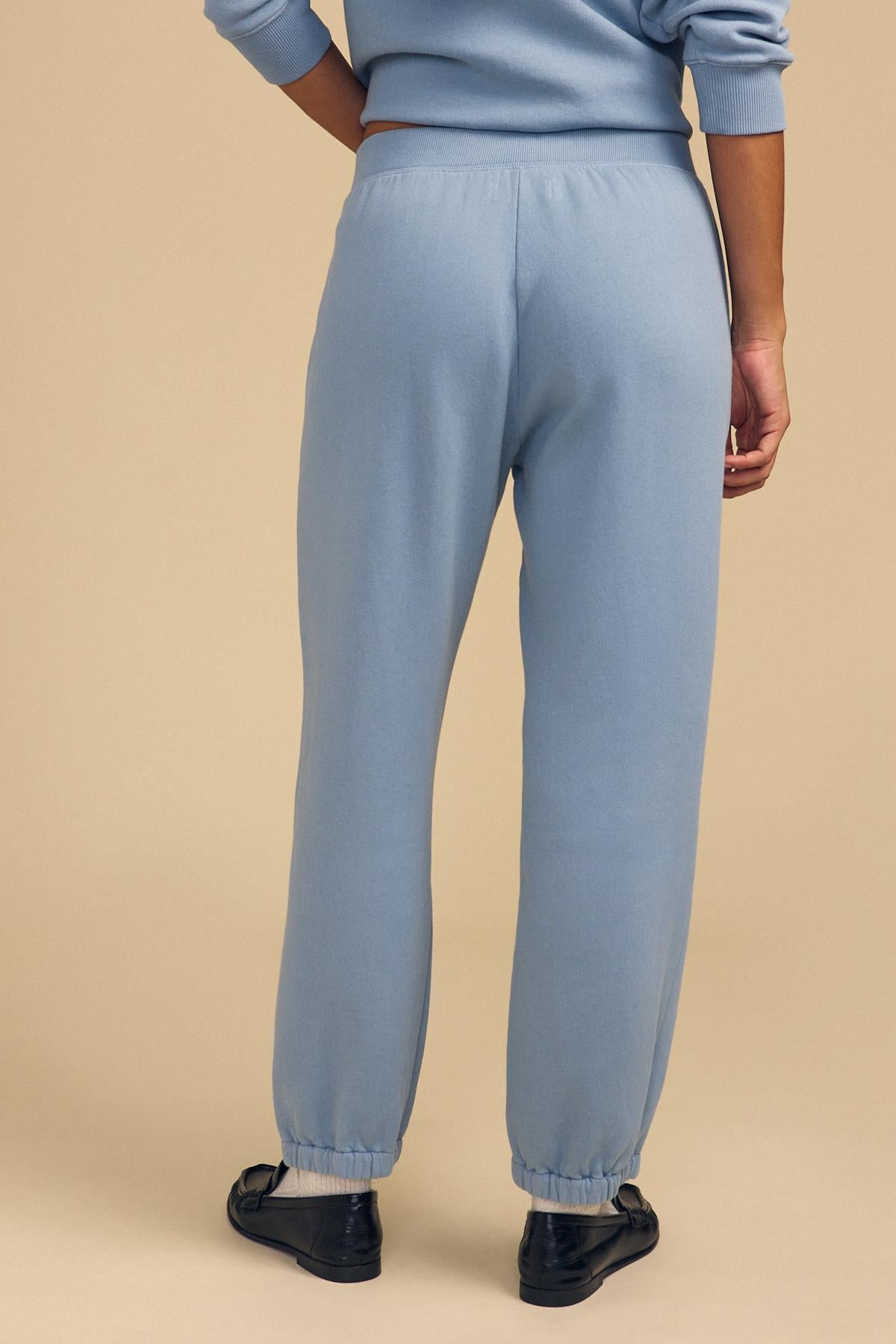 Person on a beige background wearing Velvet by Graham & Spencer ZARA SWEATPANT and matching cotton fleece sweatshirt, with black flats, shown from the back.