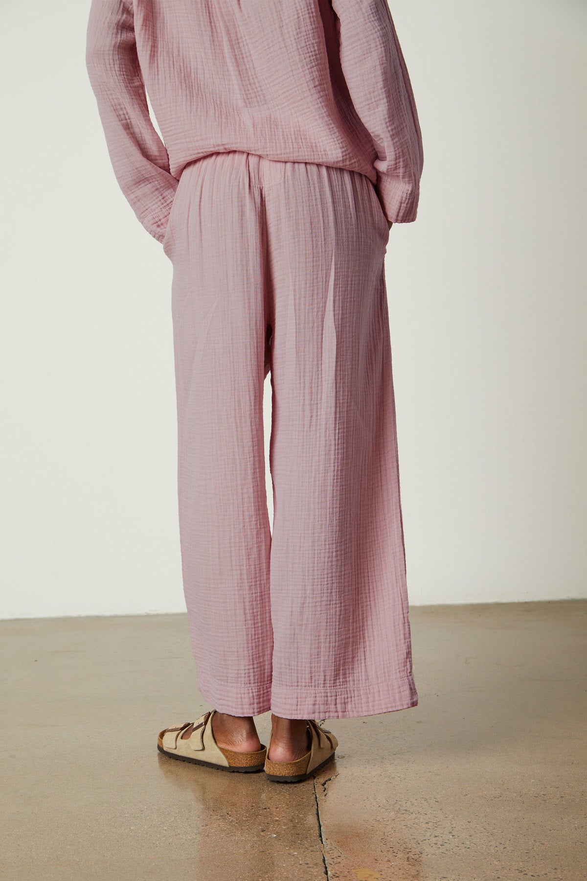 The back of a woman wearing the Jenny Graham Home pink PAJAMA PANT jumpsuit.-26311382630593