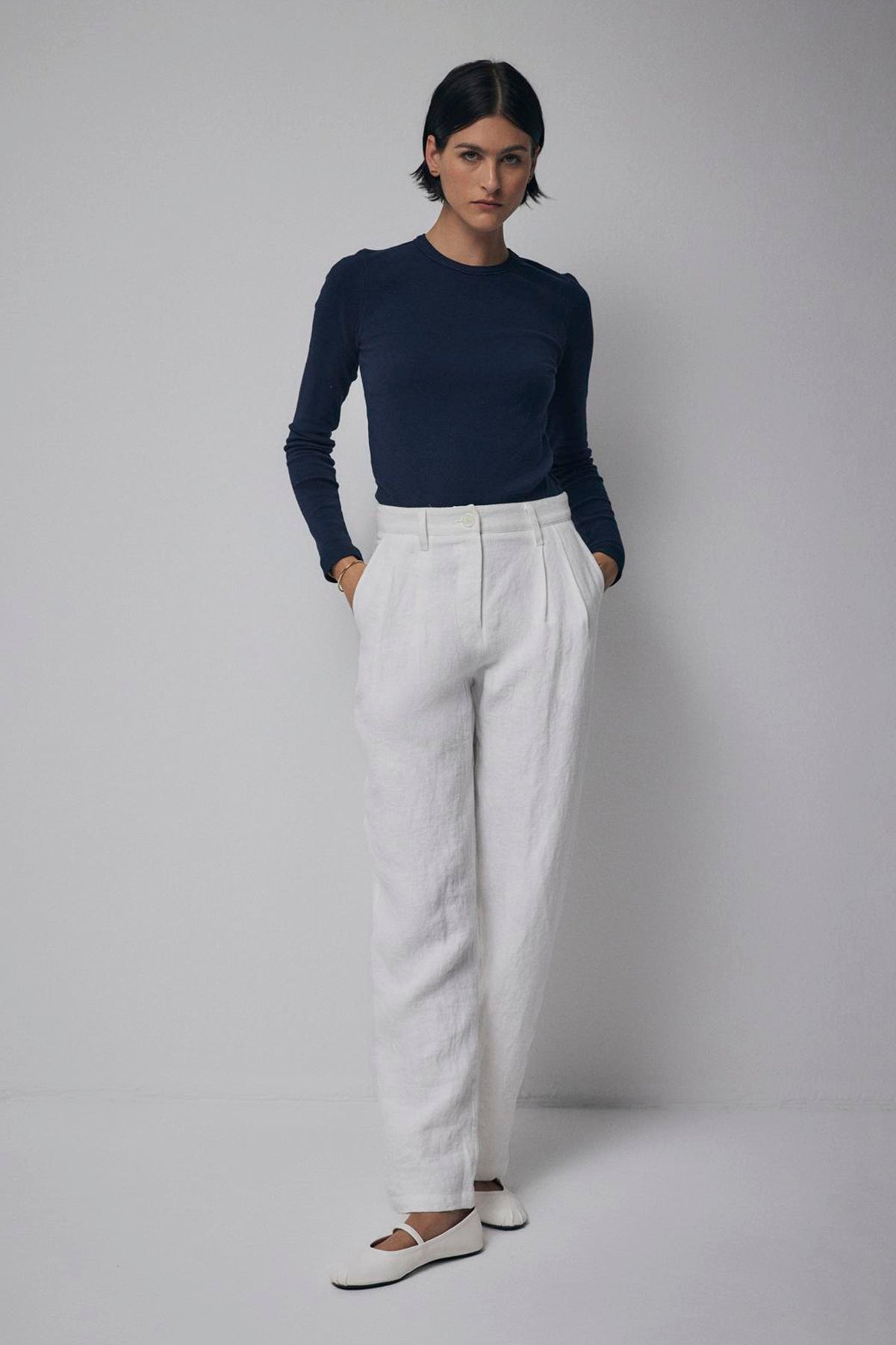  Woman in a navy blue top and Velvet by Jenny Graham's POMONA PANT posing against a gray background. 