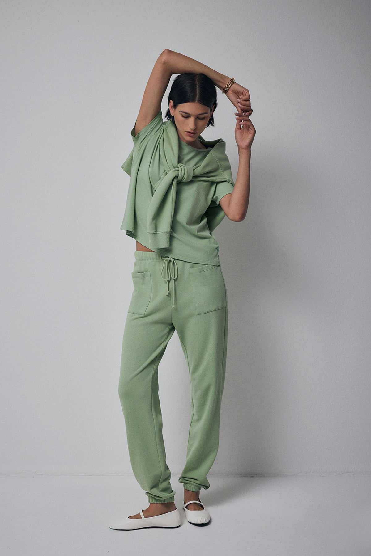 A model wearing a Velvet by Jenny Graham Ynez Sweatshirt in organic cotton green and joggers.-36212432601281