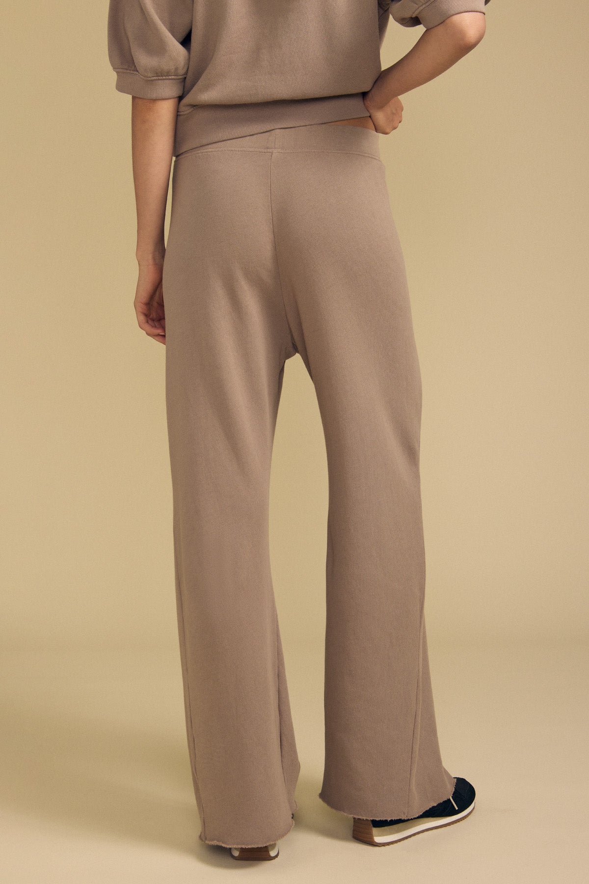 Front view of QHILLA cotton fleece wide leg sweatpant showcasing taupe color and wide-leg fit with a beige background-41940415676609
