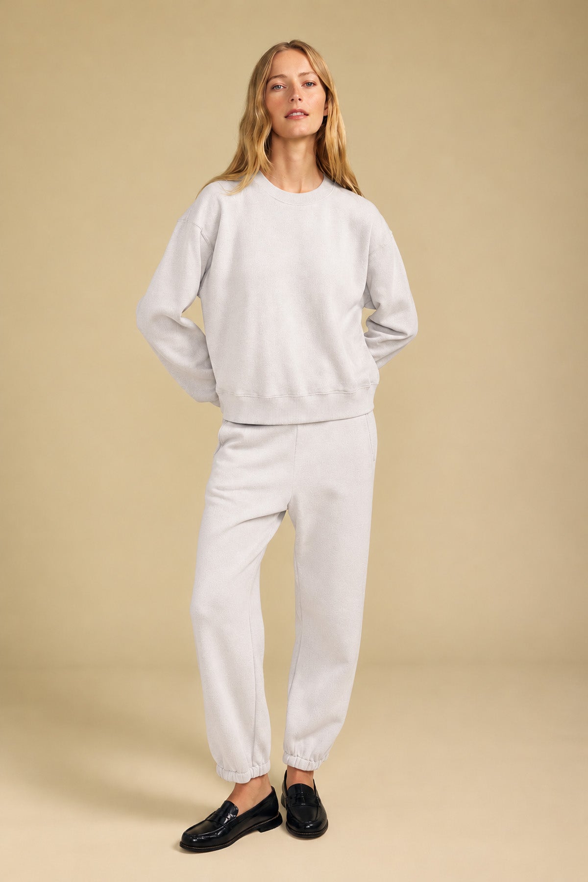 Woman wearing a relaxed YOKO SWEATSHIRT and matching jogger pants with black loafers.-46320580427969
