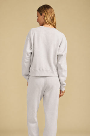 Back view of a person wearing a light gray YOKO SWEATSHIRT and matching cotton fleece sweatpants.