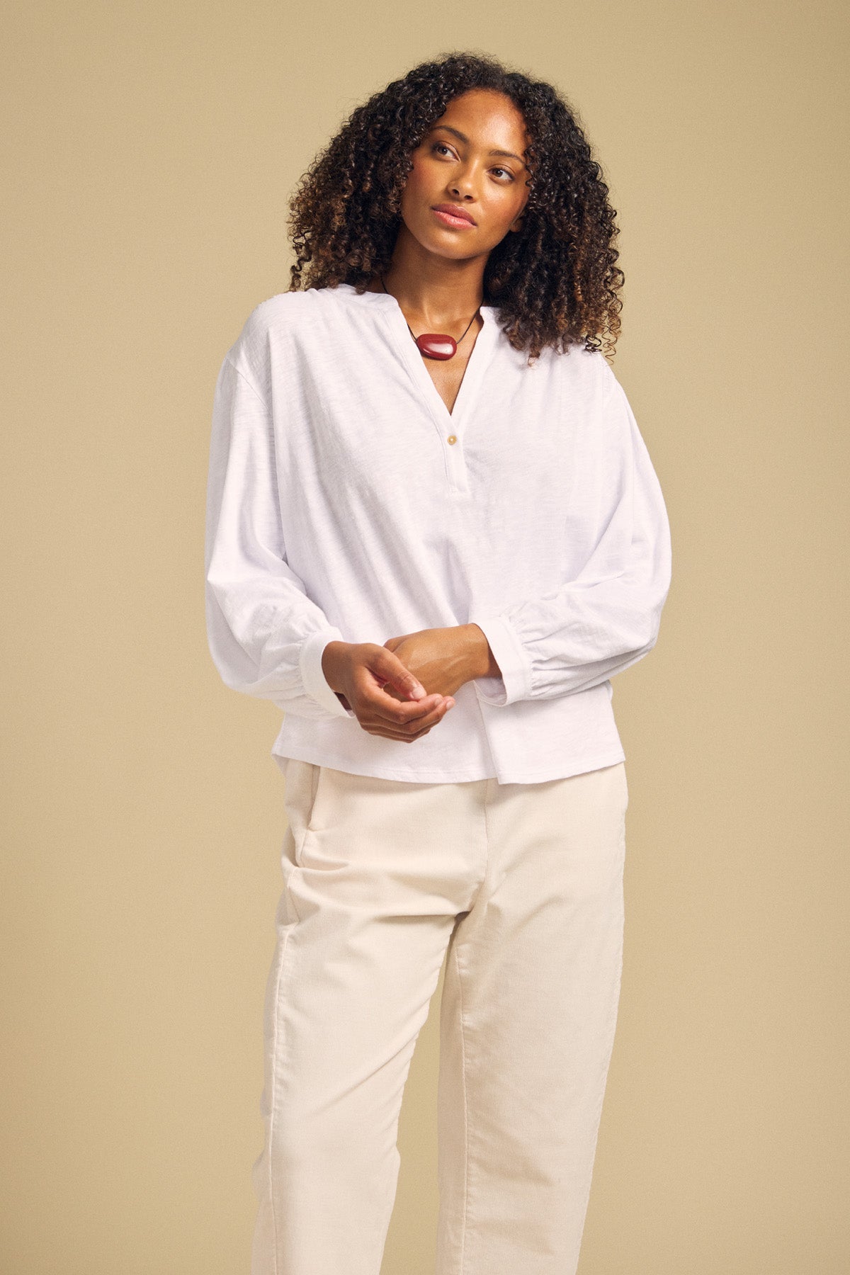 Front view of white KNOX cotton slub 3/4 sleeve split neck tee showcasing relaxed fit on model with beige background
