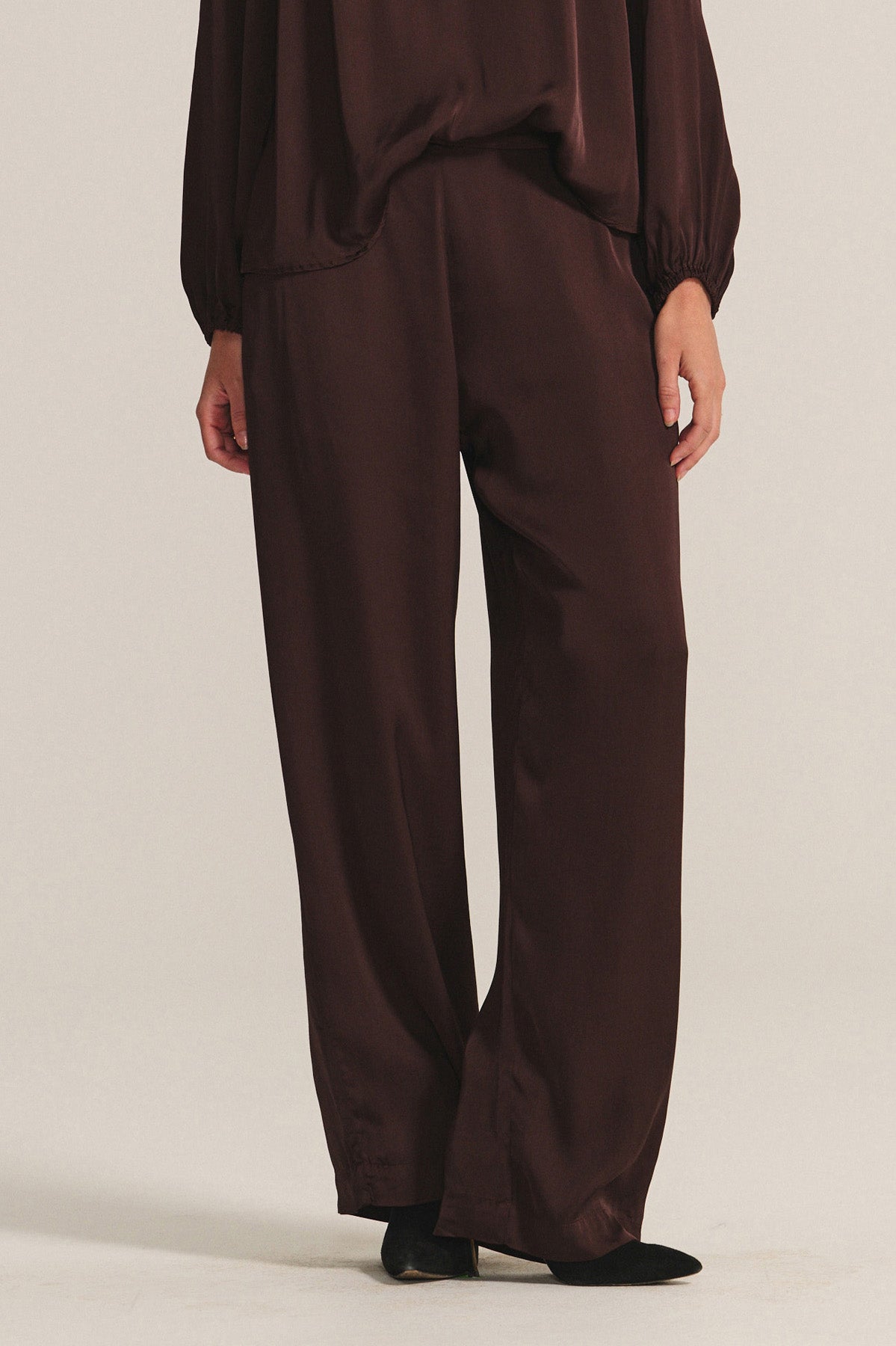   A person wearing the LARKIN PANT by Velvet by Graham & Spencer, styled with a matching top, stands against a plain light background. 