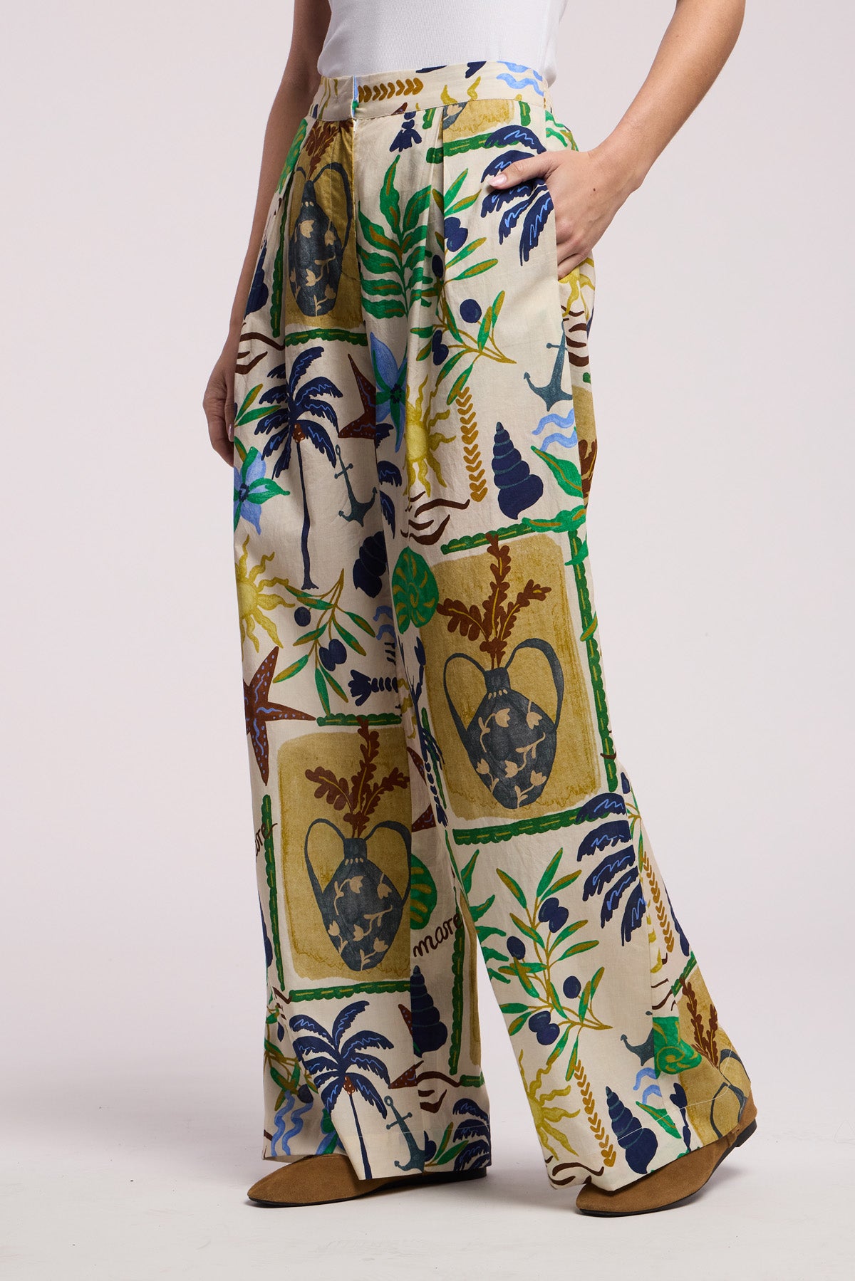Model wears the TRIXIE PANT by Velvet by Graham & Spencer, featuring a wide-leg silhouette with vibrant tropical and marine life patterns, styled with a white top and brown shoes.