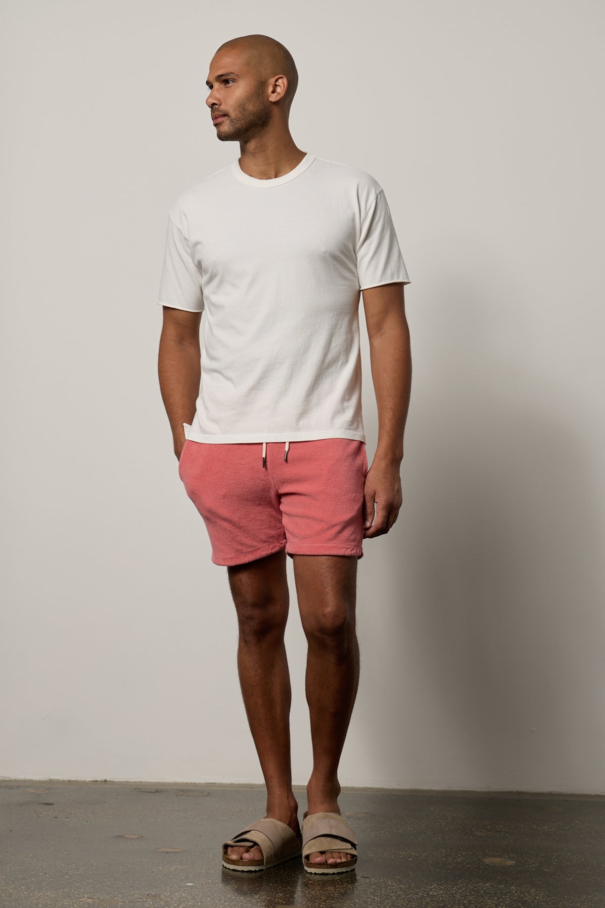   A man wearing OZZIE TERRY SHORT by Velvet by Graham & Spencer shorts and a white t - shirt. 