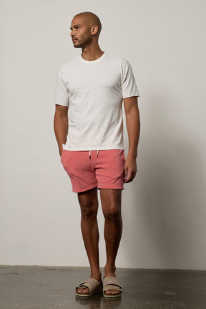 A man wearing OZZIE TERRY SHORT by Velvet by Graham & Spencer shorts and a white t - shirt.