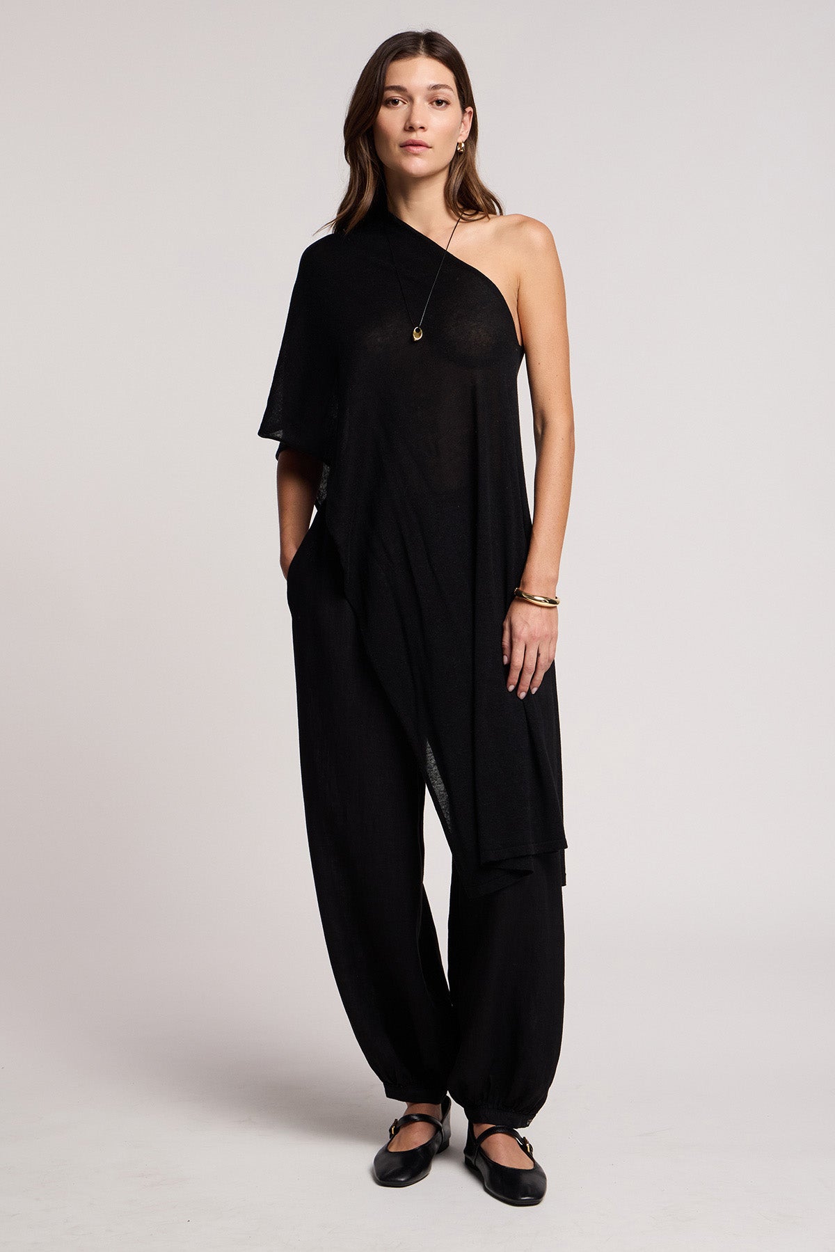 A woman wears the FLOREN SWEATER by Velvet by Graham & Spencer, paired with black shoes and simple jewelry, against a plain background.