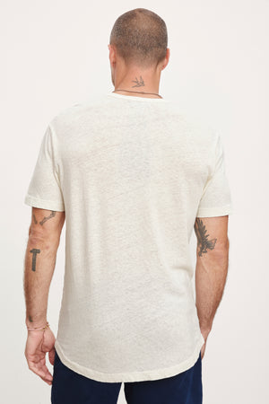 Rear view of a man wearing a Velvet by Graham & Spencer DAVEY TEE showing tattoos on his arms and neck.