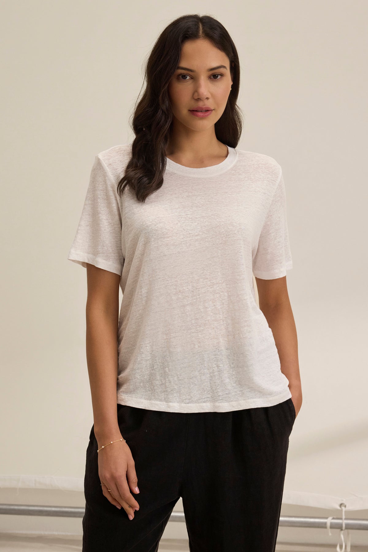 A person models the relaxed fit of the HERITAGE LINEN KNIT TEE by Velvet by Graham & Spencer, paired with black pants against a plain background.-38879369167041