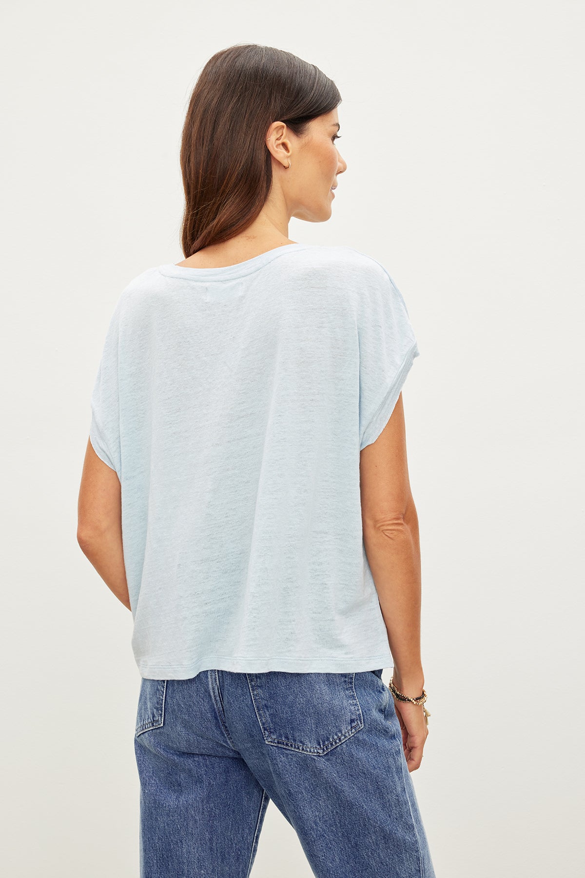 The back view of a woman wearing jeans and a HUDSON CREW NECK TEE by Velvet by Graham & Spencer.-35967645319361