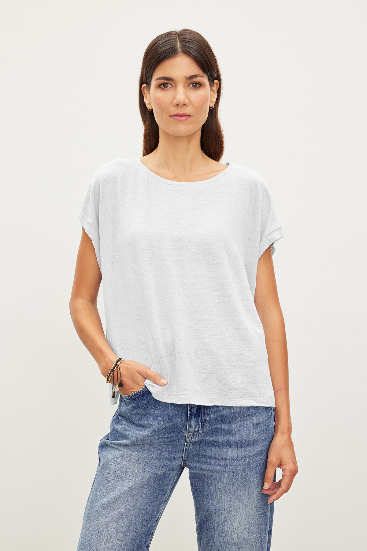 A woman wearing a white HUDSON CREW NECK TEE by Velvet by Graham & Spencer and jeans.-35967645483201