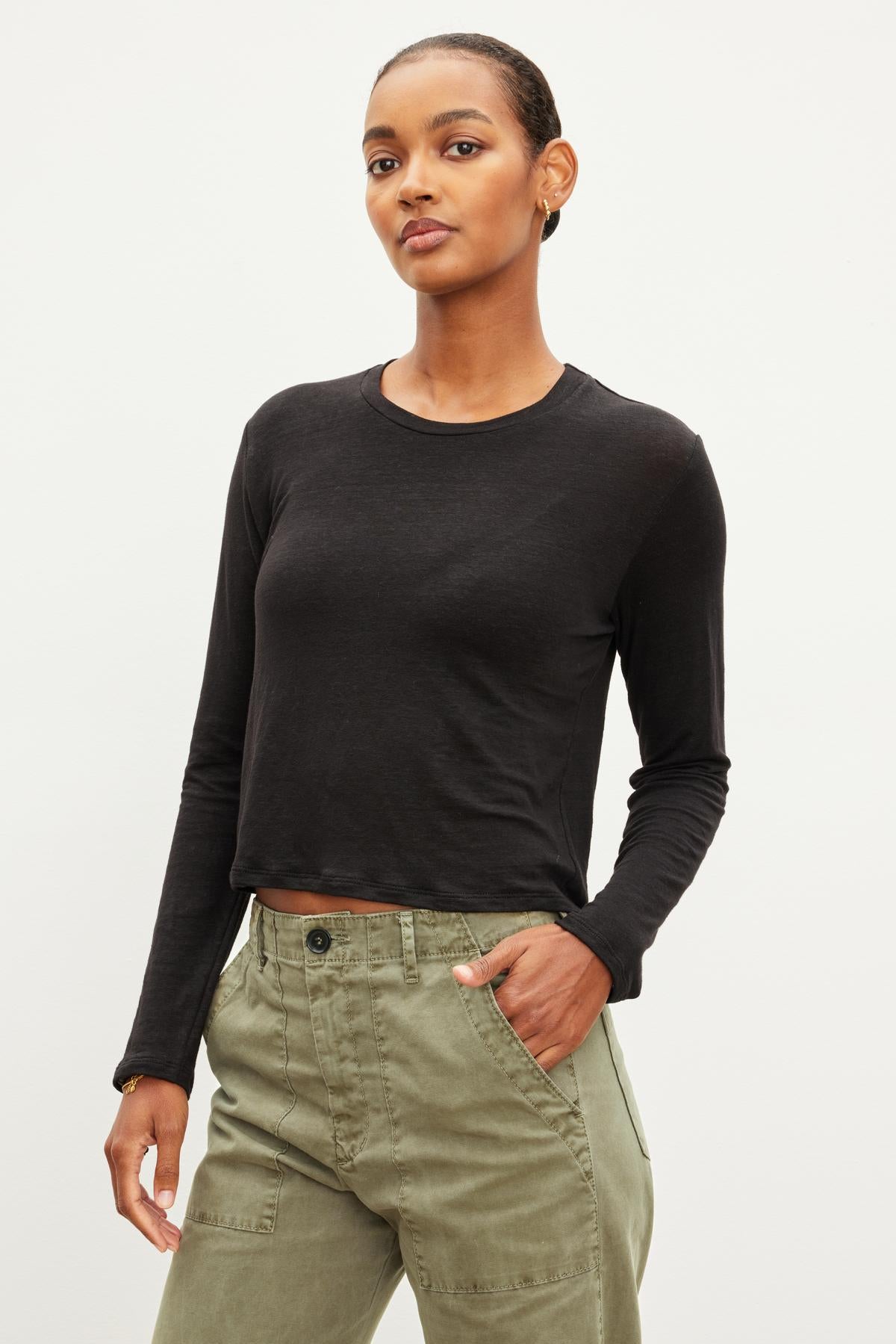 A woman in a KARA CREW NECK TEE by Velvet by Graham & Spencer and olive green, lightweight linen pants posing against a white background.-36425742549185