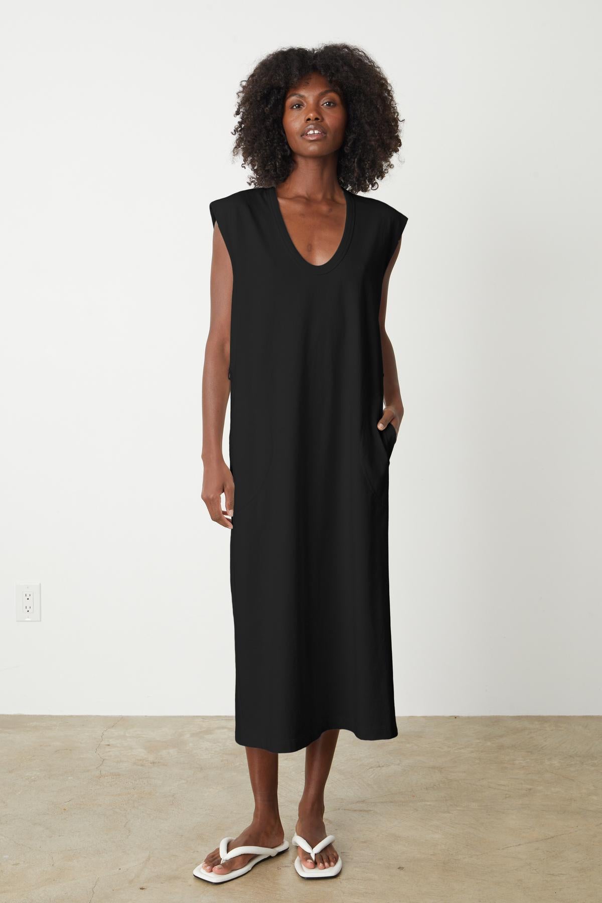 A woman wearing a Velvet by Graham & Spencer MACI SCOOP NECK DRESS and flip flops.-35201180303553