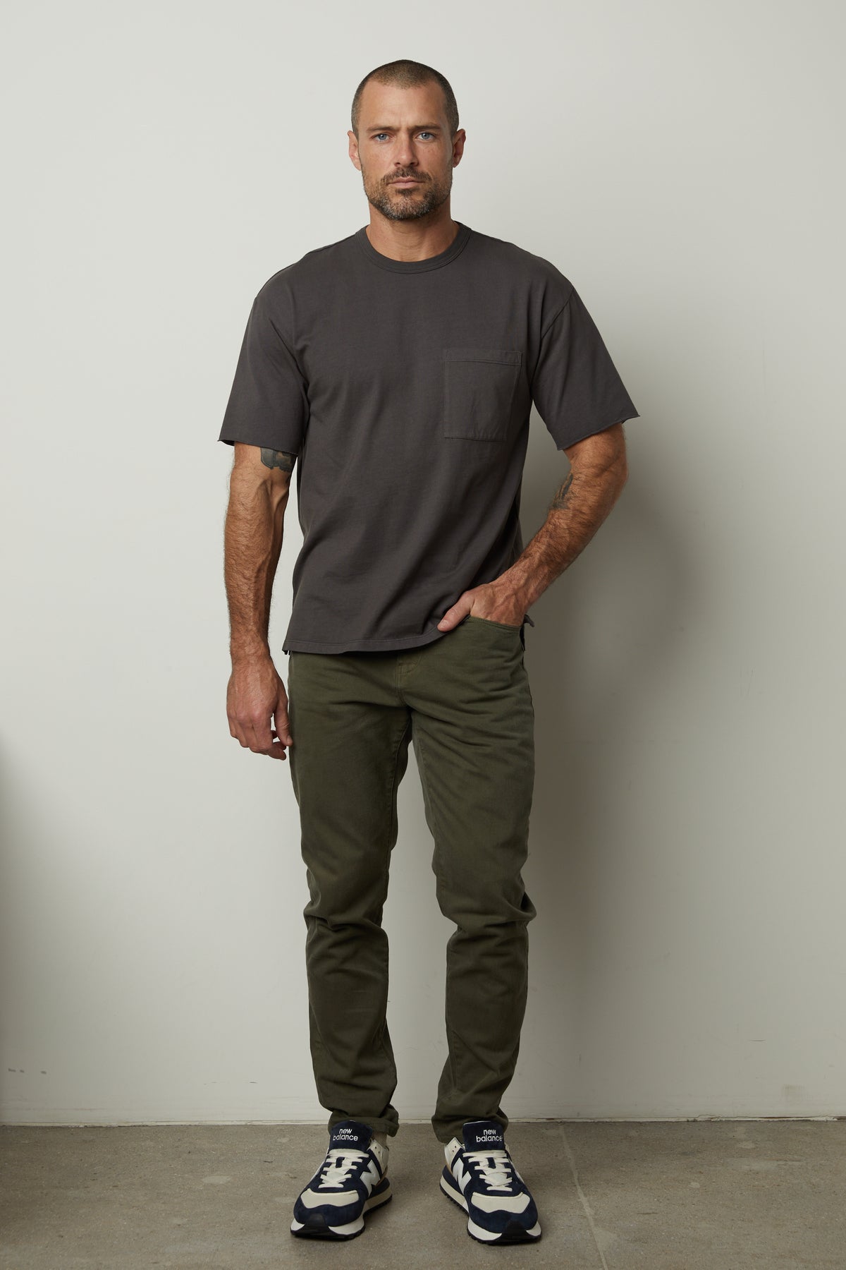 A man wearing Velvet by Graham & Spencer JOSEPH COTTON CANVAS PANT, made of cotton canvas material, and a t-shirt.-26860194037953