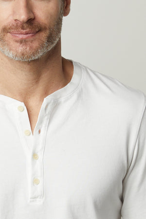 A man wearing a Velvet by Graham & Spencer REMI HENLEY t-shirt.