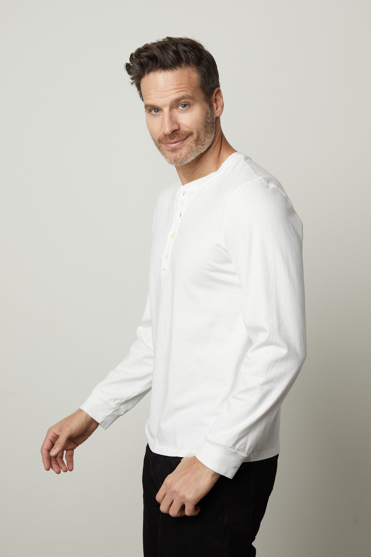   A man wearing a white Velvet by Graham & Spencer REMI HENLEY t - shirt. 
