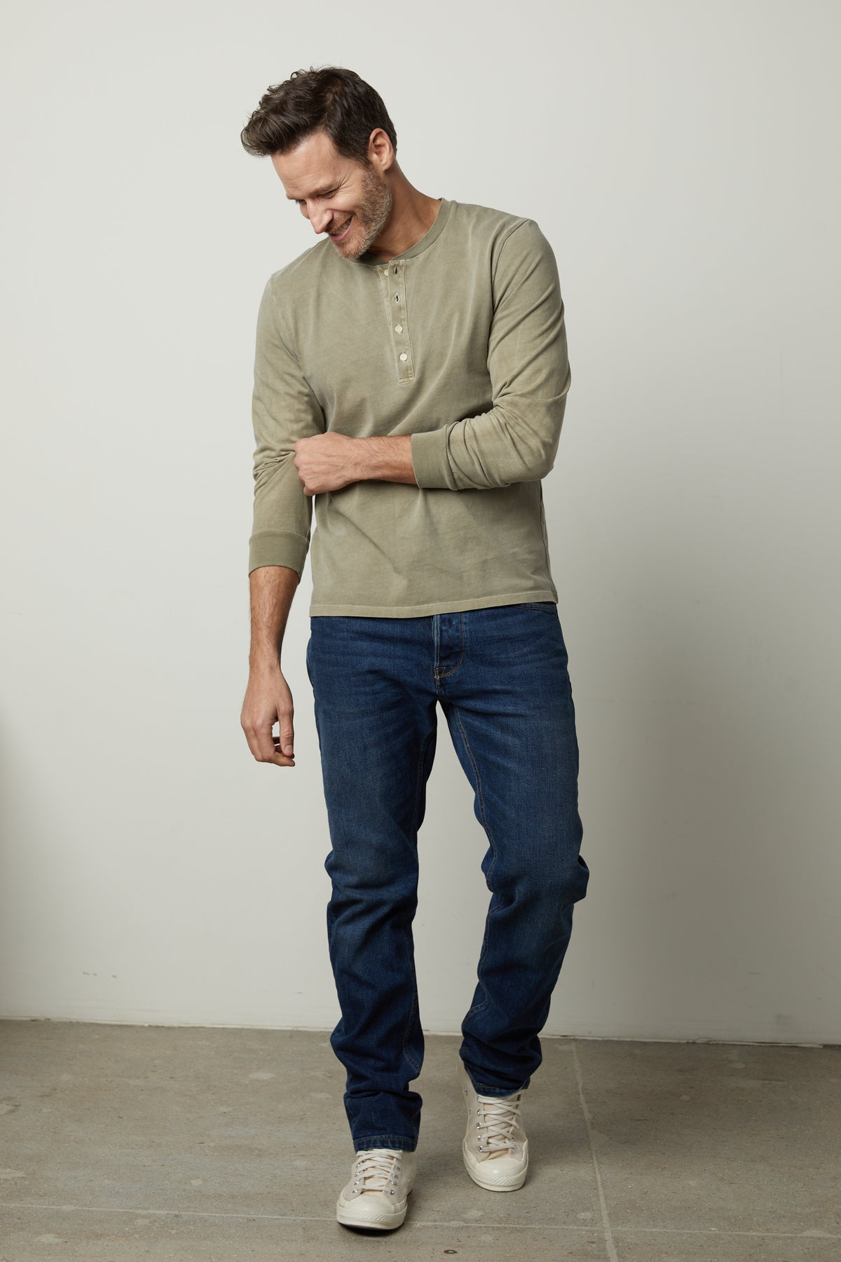 A man wearing REMI HENLEY jeans and a long-sleeved shirt by Velvet by Graham & Spencer.-26827678056641