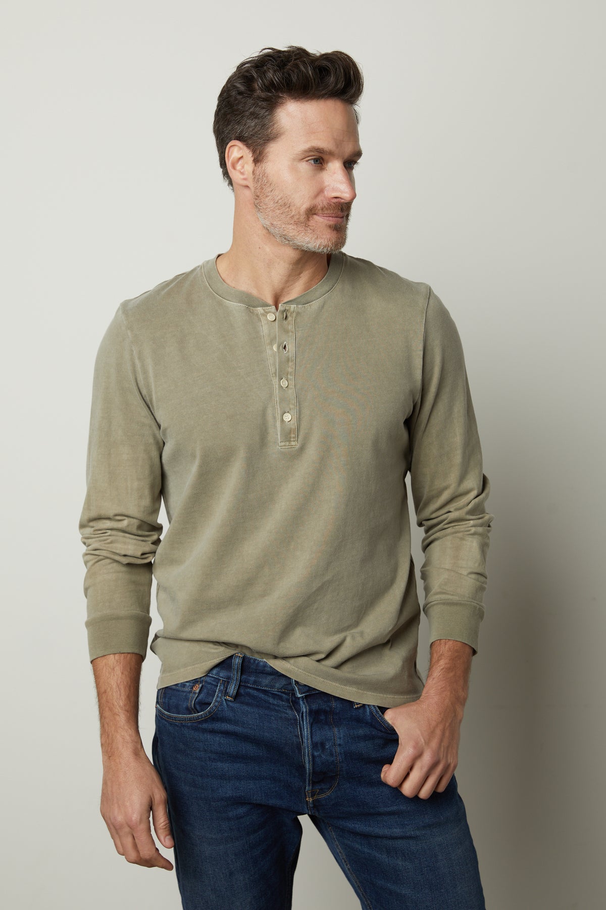 The man is wearing jeans and a REMI HENLEY shirt by Velvet by Graham & Spencer.-26827678023873