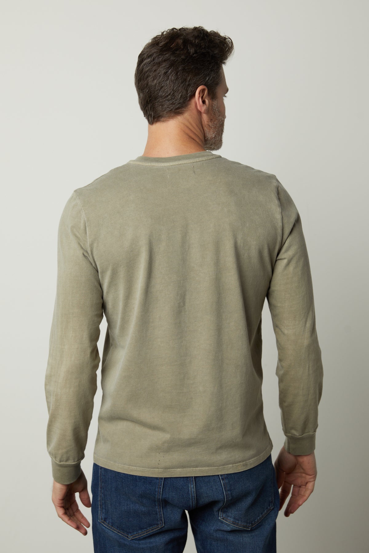 The back view of a man wearing Velvet by Graham & Spencer REMI HENLEY jeans and a long-sleeved shirt.-26827678122177