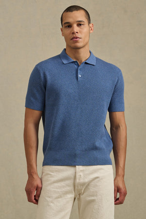 A man stands facing forward against a neutral background, wearing the LOWELL SWEATER POLO by Velvet by Graham & Spencer and off-white pants.