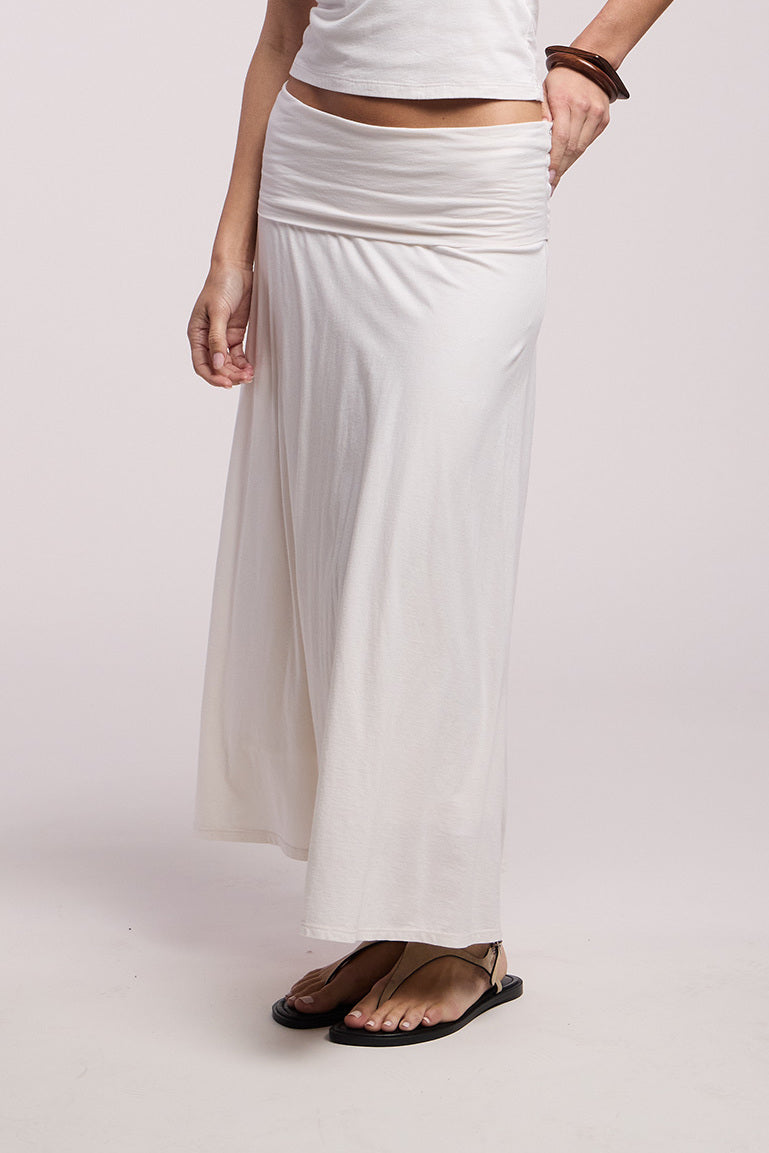 A person models the LUELLA SKIRT by Velvet by Graham & Spencer with a sleeveless top, black sandals, and brown bracelets against a plain background.