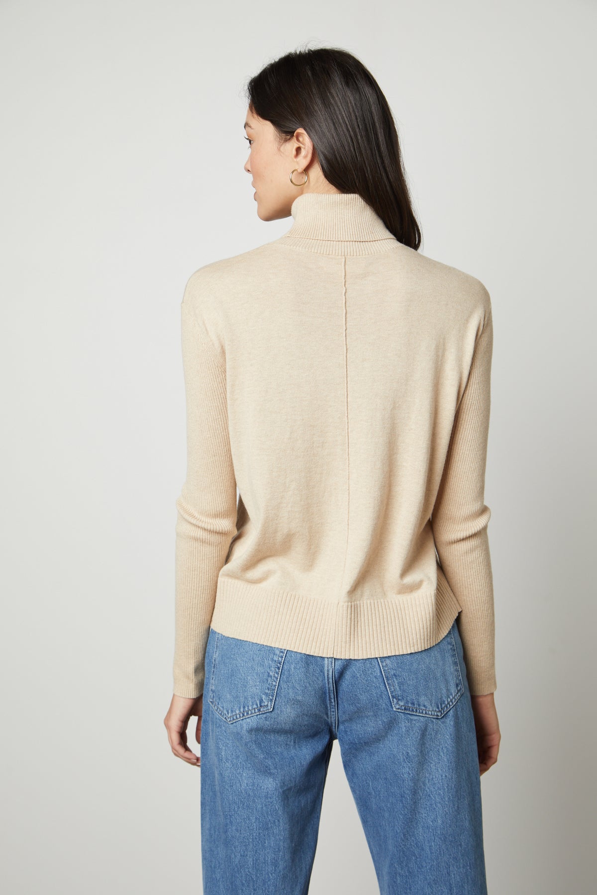   The back view of a woman wearing a Velvet by Graham & Spencer SALLY MOCK NECK SWEATER. 