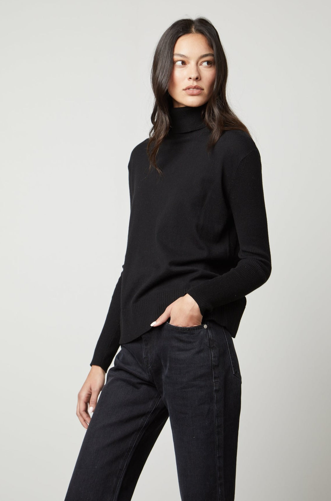   A woman wearing a SALLY MOCK NECK SWEATER by Velvet by Graham & Spencer, fabricated with a cotton-cashmere blend. 