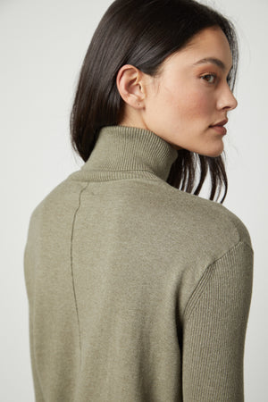 The back view of a woman wearing a Velvet by Graham & Spencer SALLY MOCK NECK SWEATER.