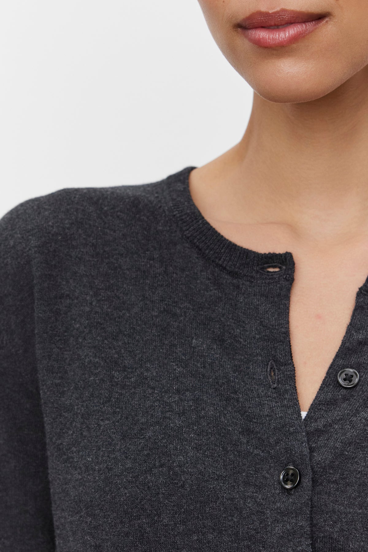 Close-up of a person wearing the VIOLETTE CARDIGAN by Velvet by Graham & Spencer, with two buttons fastened and one unbuttoned. Only the lower half of their face and part of their torso are visible.-37676236275905