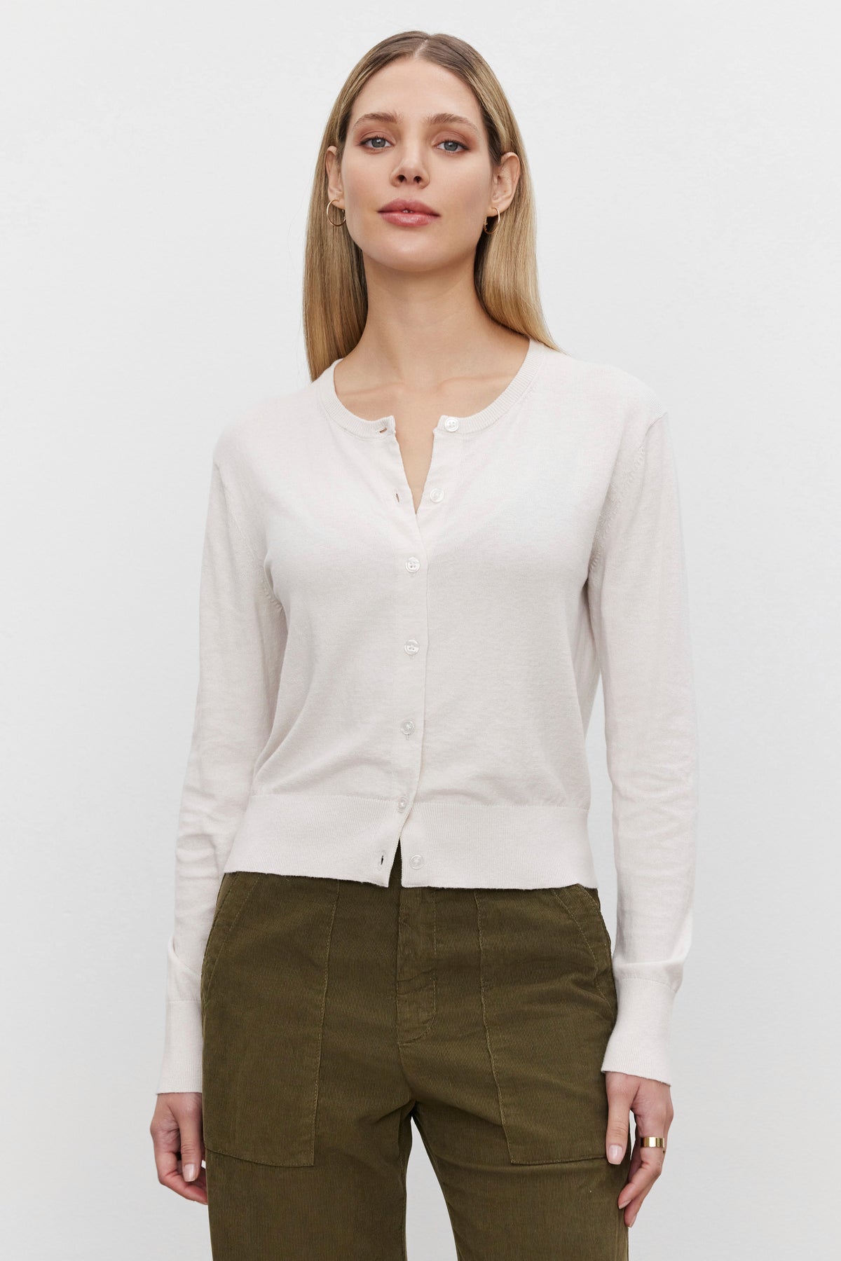 A person wearing the VIOLETTE CARDIGAN from Velvet by Graham & Spencer, made of a luxurious cotton cashmere blend, paired with olive green pants, stands against a plain white background.-37676917752001