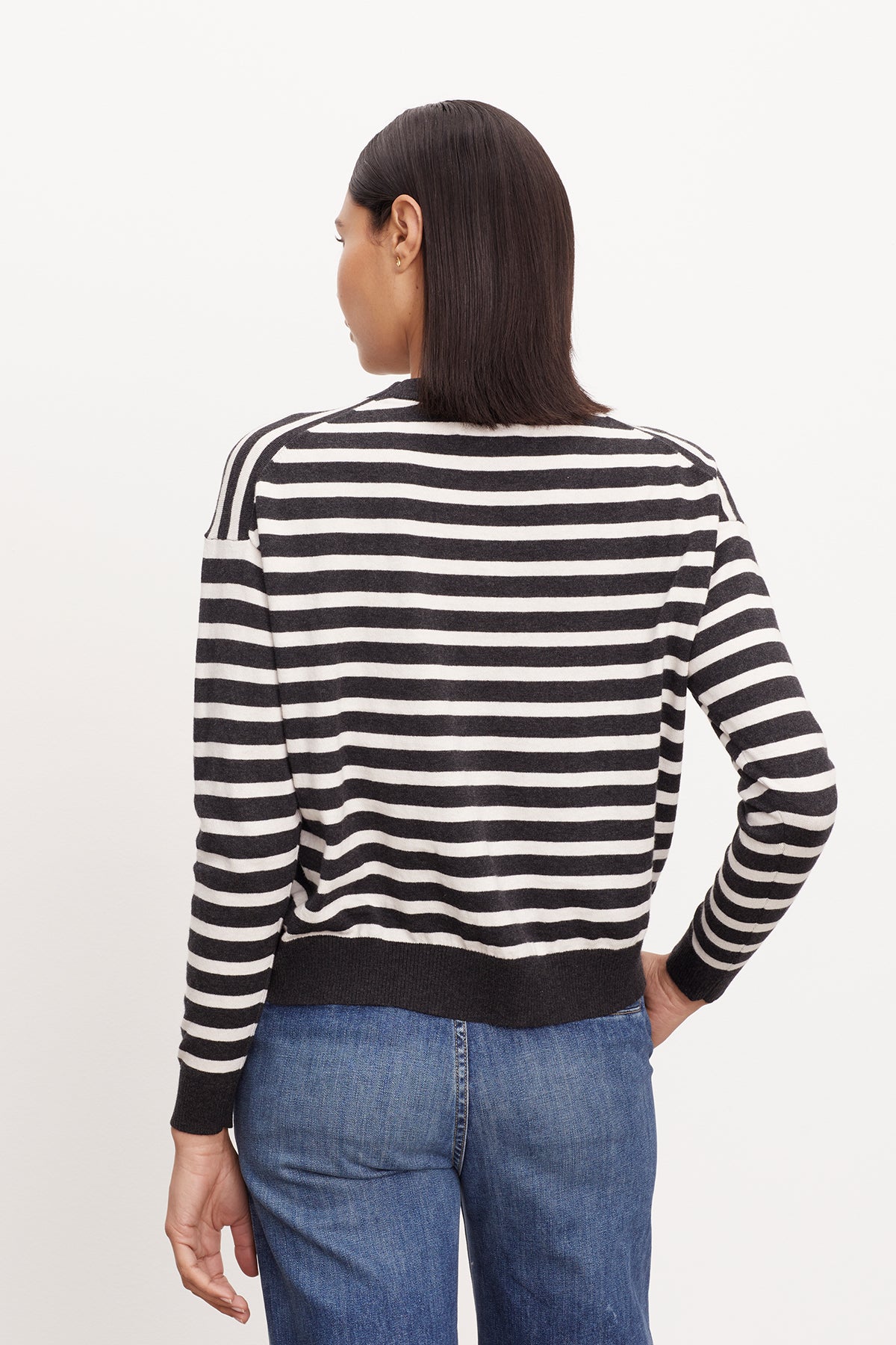 The back view of a woman wearing a Velvet by Graham & Spencer ALISTER STRIPED CREW NECK SWEATER.-26799864742081