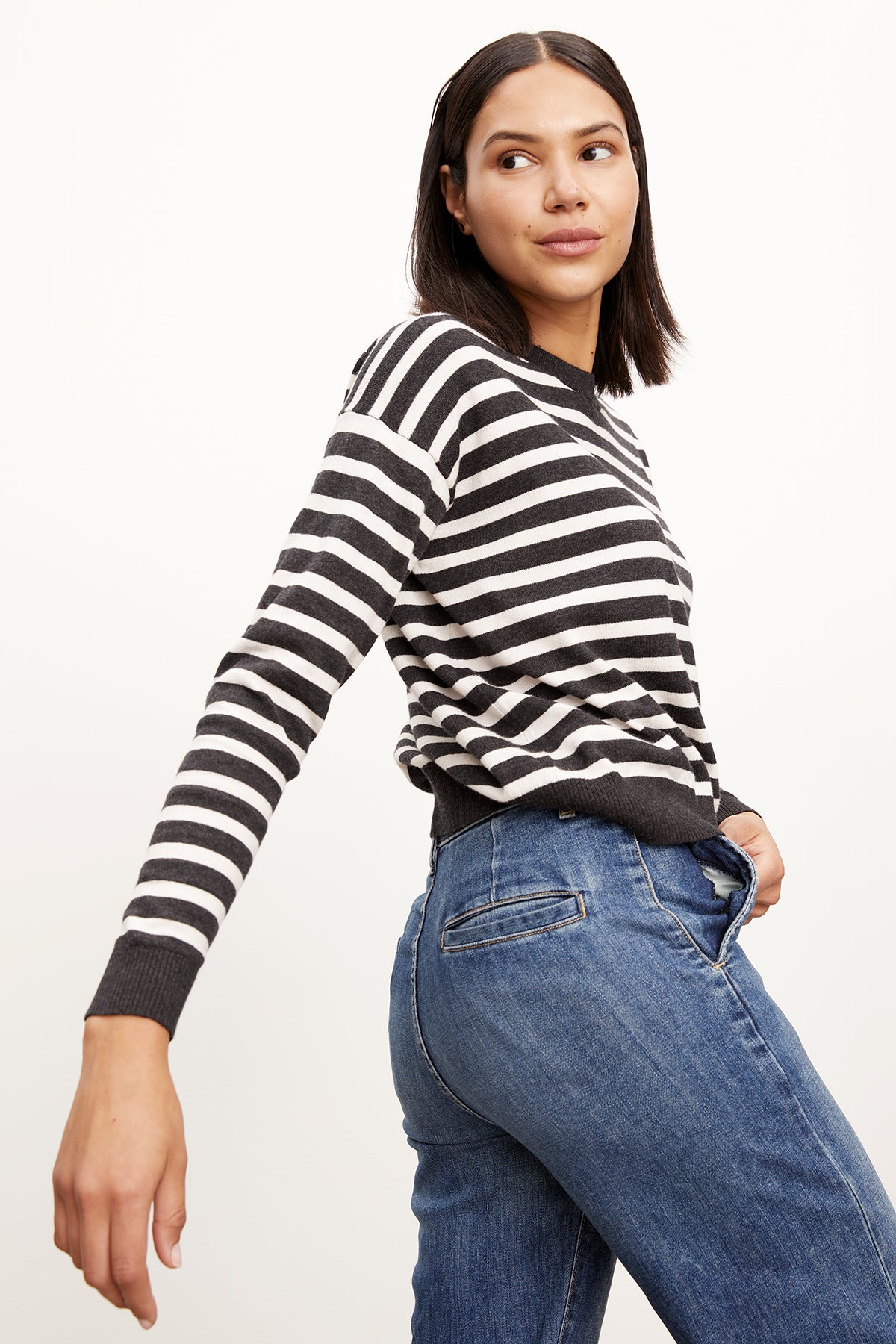 A woman wearing an ALISTER STRIPED CREW NECK SWEATER by Velvet by Graham & Spencer and jeans.-26799864807617