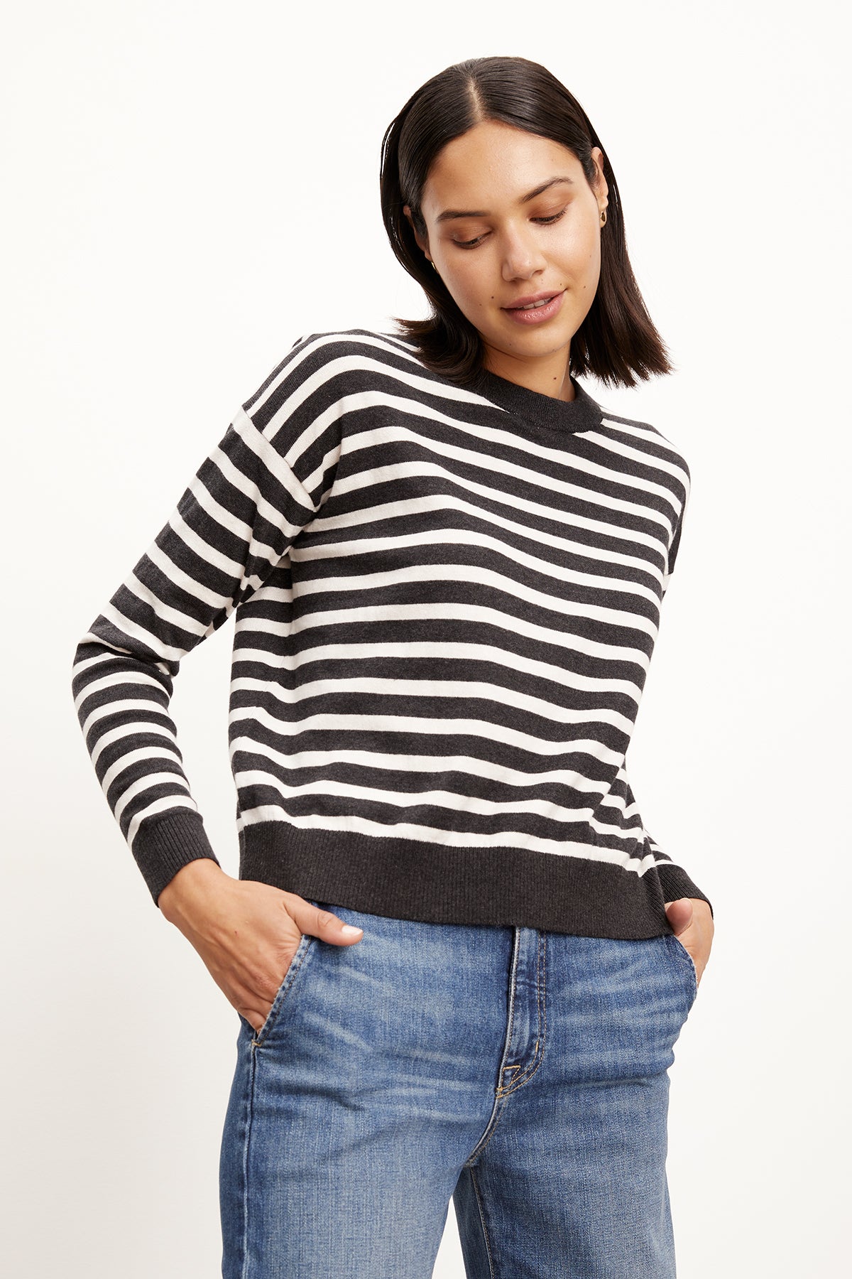   A model wearing the Velvet by Graham & Spencer ALISTER STRIPED CREW NECK SWEATER and jeans. 
