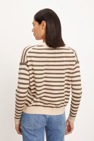 The back view of a woman wearing the Velvet by Graham & Spencer ALISTER STRIPED CREW NECK SWEATER and jeans.