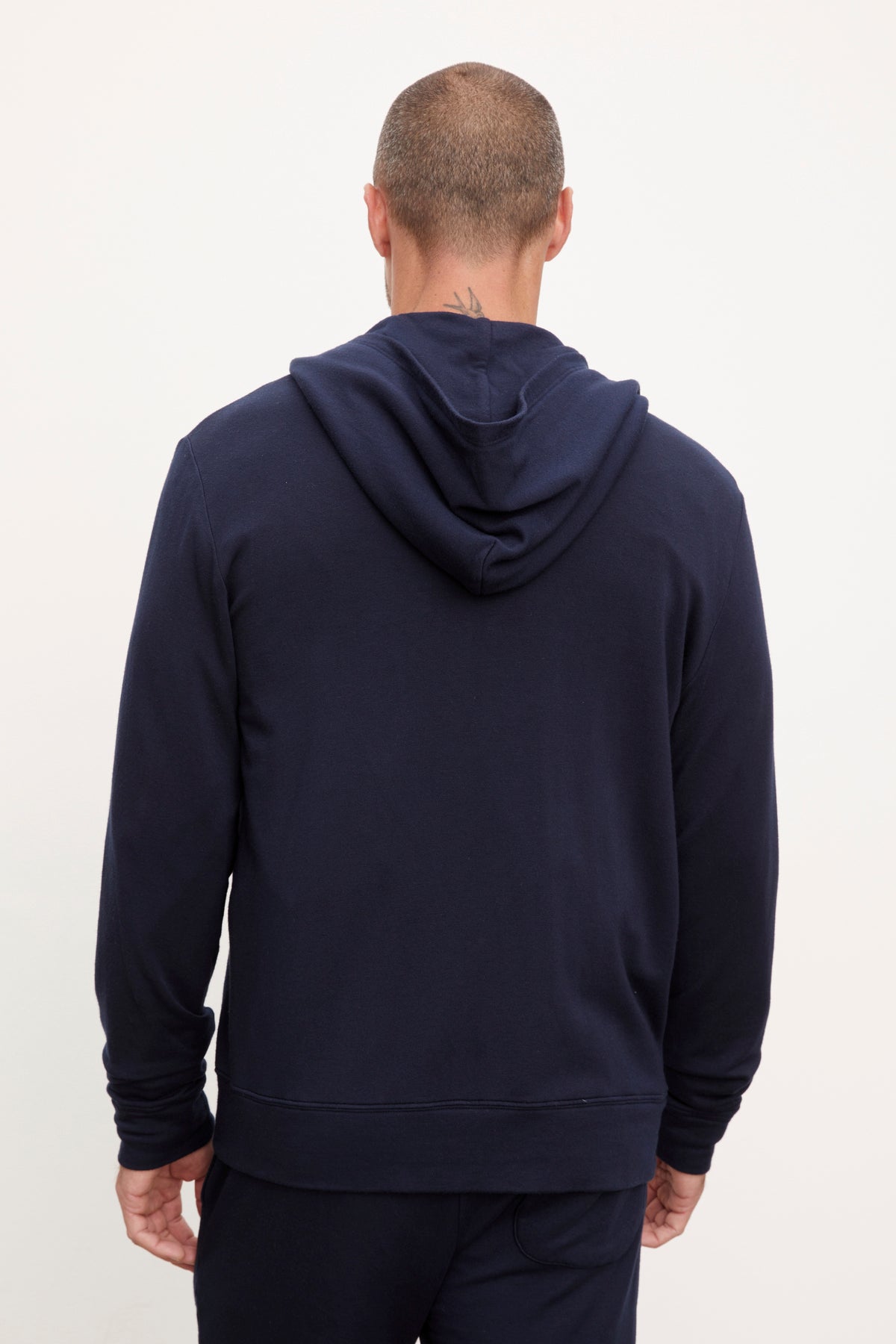   Man wearing a navy blue, medium-weight RODAN LUXE FLEECE ZIP HOODIE and matching pants, viewed from the back by Velvet by Graham & Spencer. 