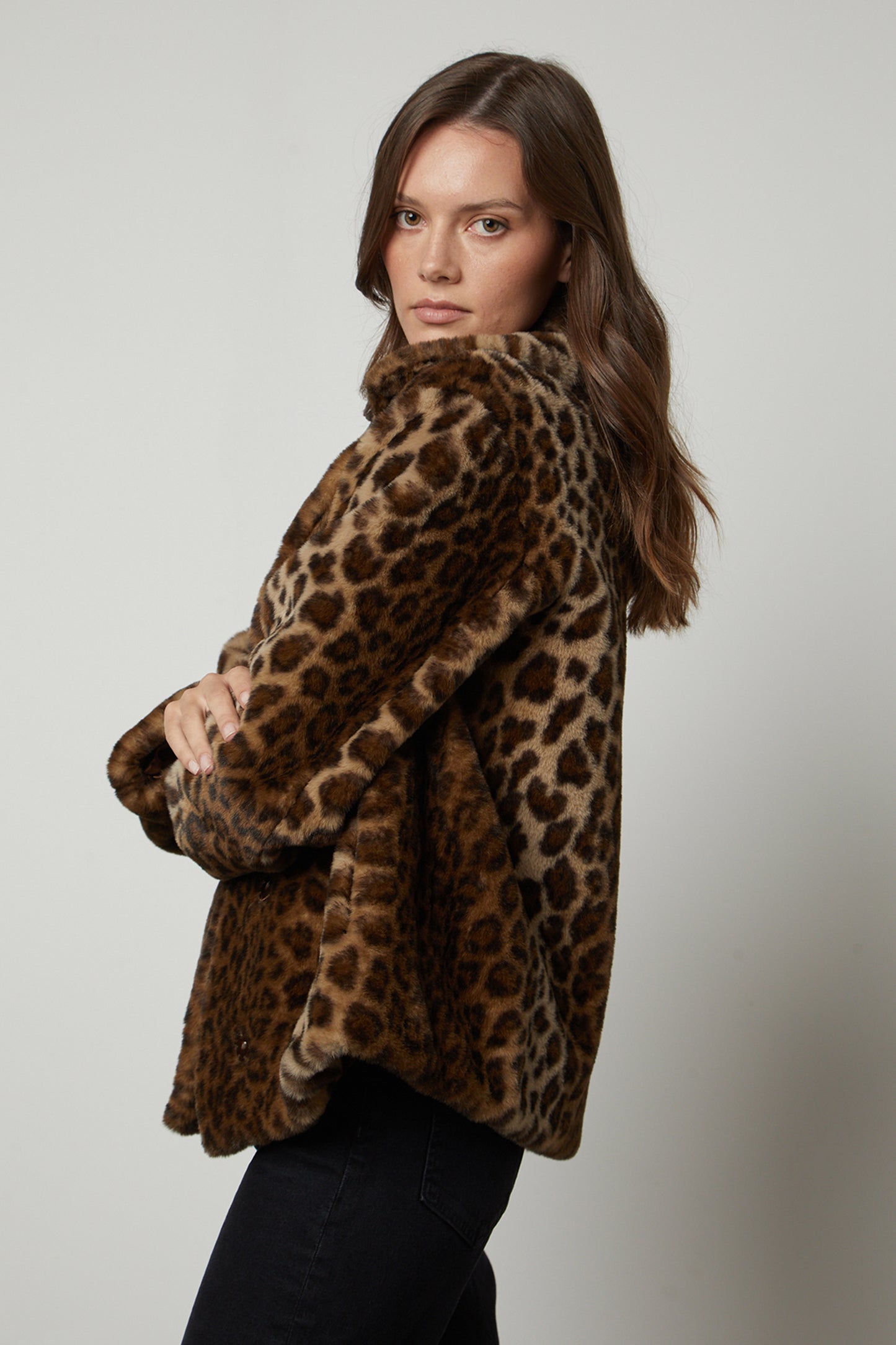 A woman wearing a AMANI LEOPARD LUX FAUX FUR JACKET by Velvet by Graham & Spencer in a double breasted style.-35626121330881