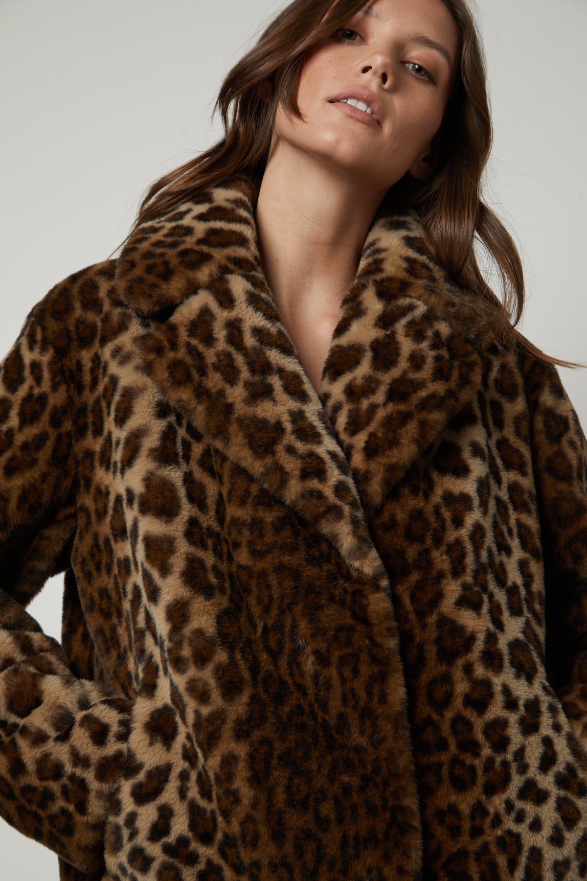   A woman wearing a AMANI LEOPARD LUX FAUX FUR JACKET by Velvet by Graham & Spencer. 