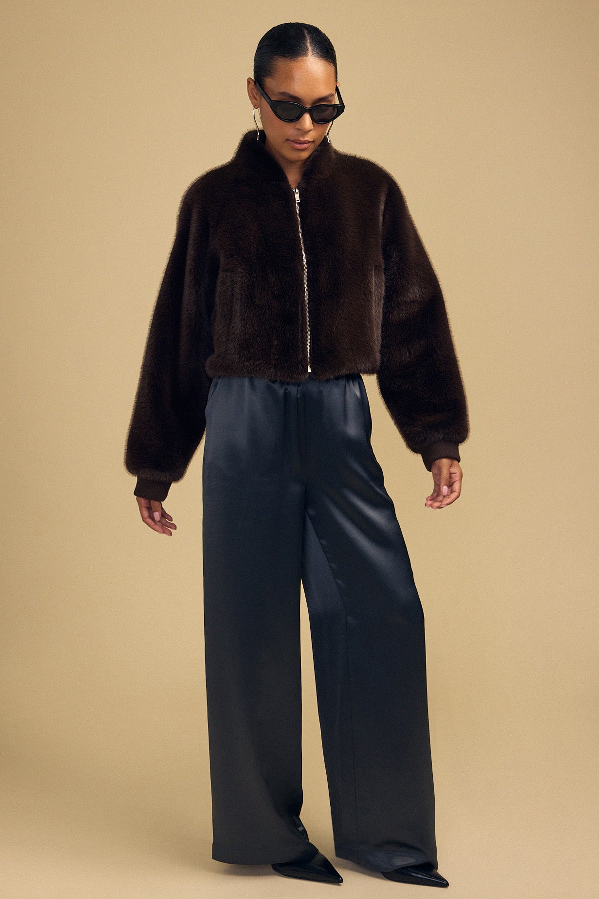 A person wearing an ARIANNA FAUX FUR BOMBER JACKET by Velvet by Graham & Spencer with wide-leg trousers.-46488089985217