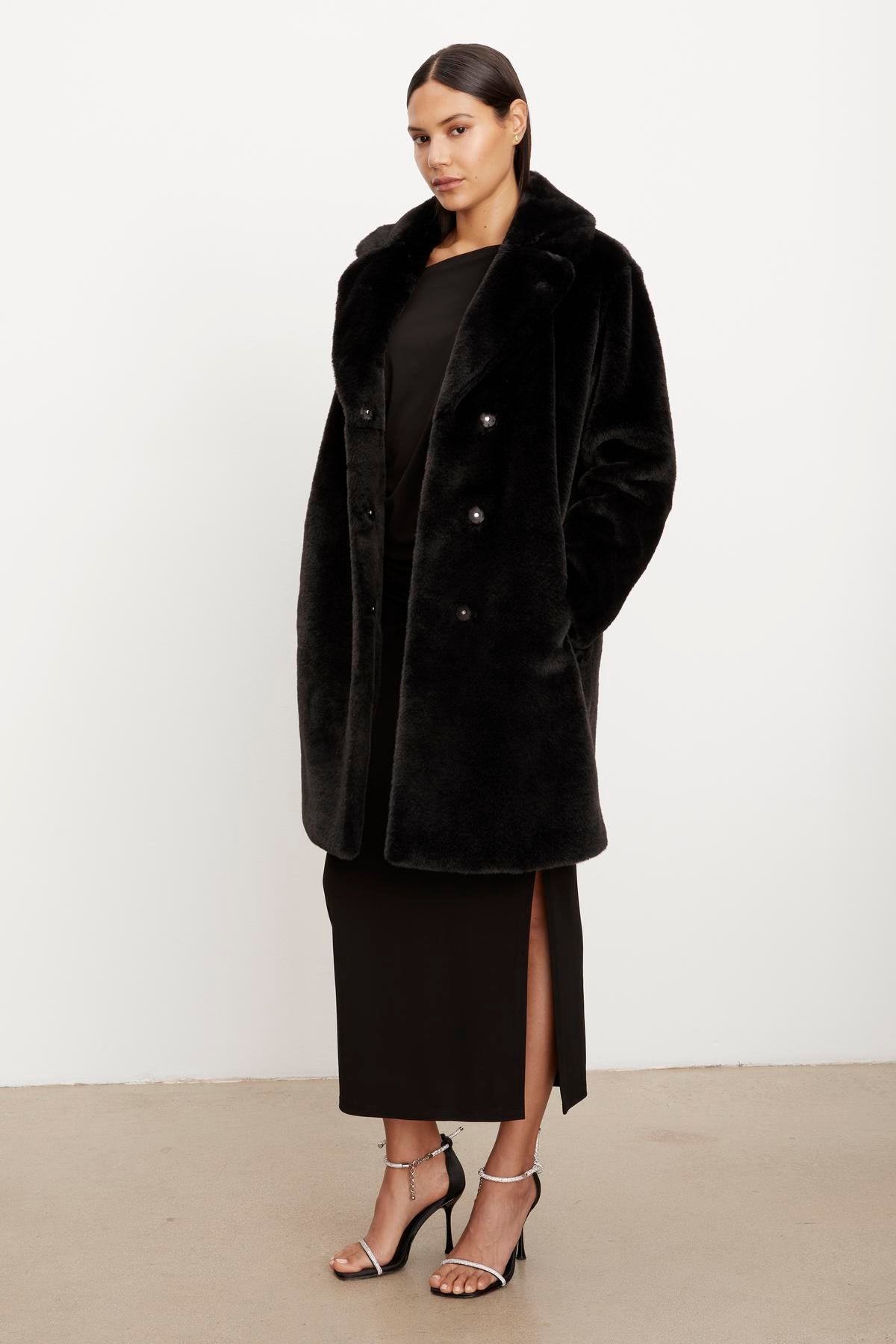 The model is wearing a Velvet by Graham & Spencer EVALYN LUX FAUX FUR COAT.-35624035287233