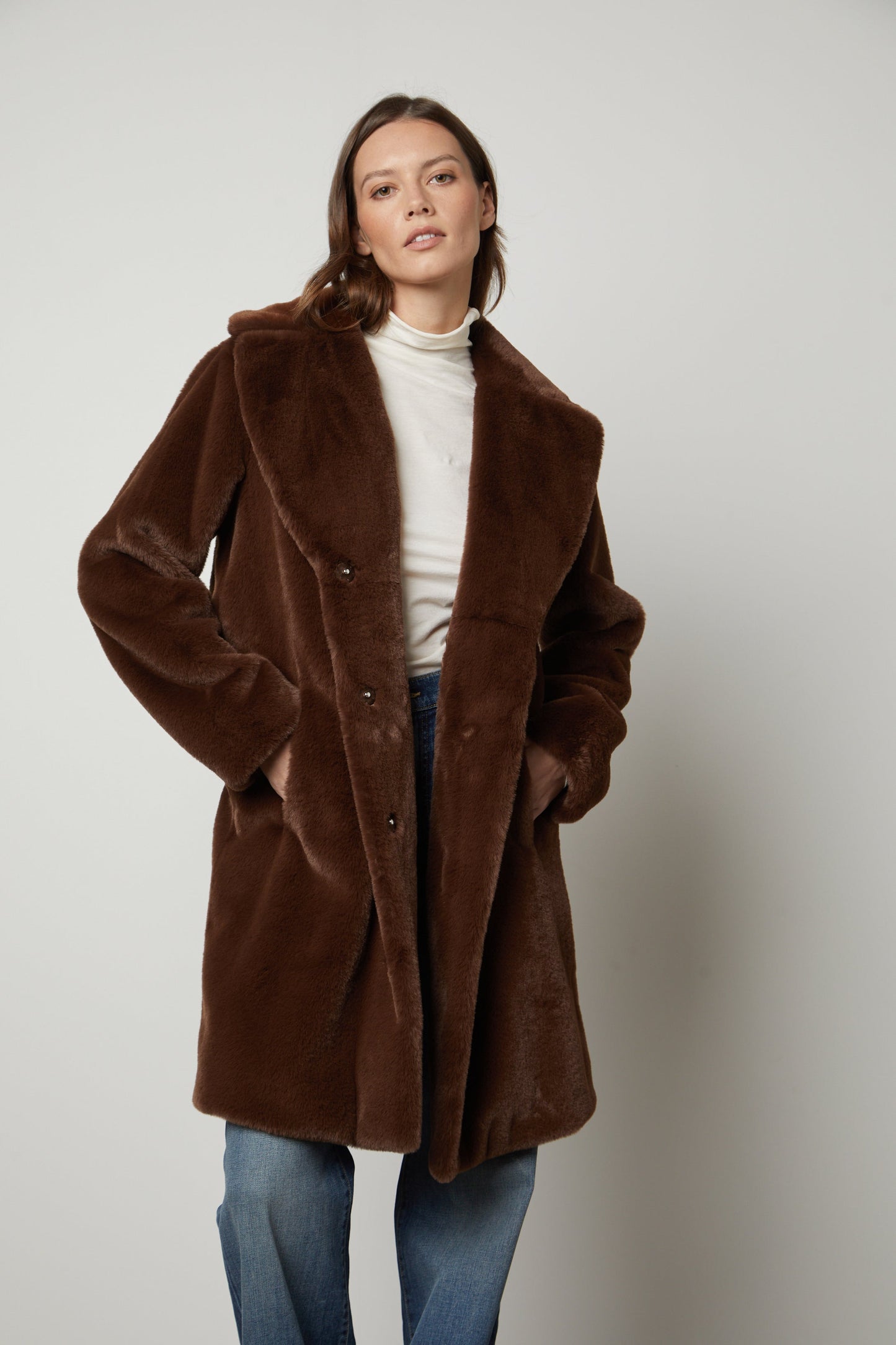 A model wearing a Brown EVALYN LUX FAUX FUR COAT by Velvet by Graham & Spencer strikes a silhouette.-35782812664001