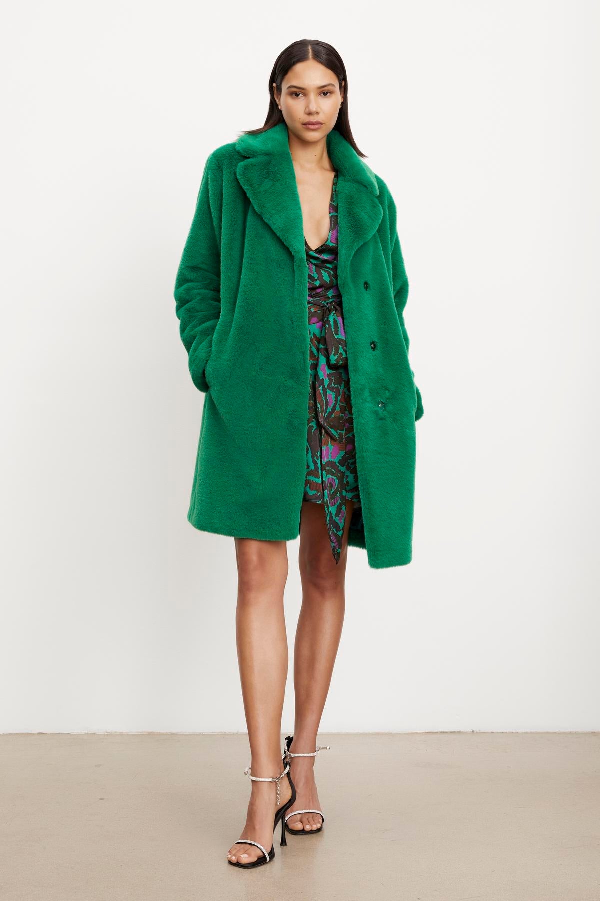 The model is wearing a green Velvet by Graham & Spencer EVALYN LUX FAUX FUR COAT.-35624128381121