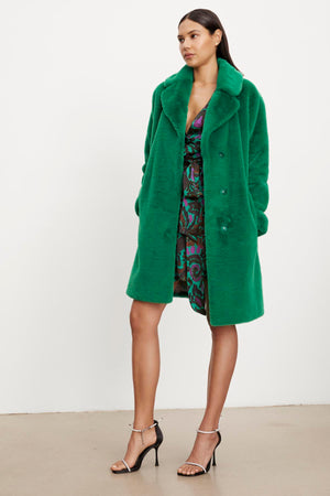 The model is wearing a Velvet by Graham & Spencer EVALYN LUX FAUX FUR COAT.