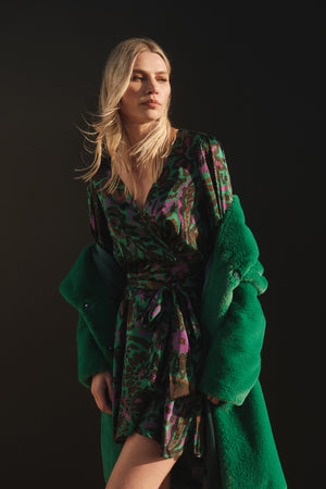 A woman in a Velvet by Graham & Spencer BRIDGET PRINTED SATIN WRAP DRESS posing for a photo.